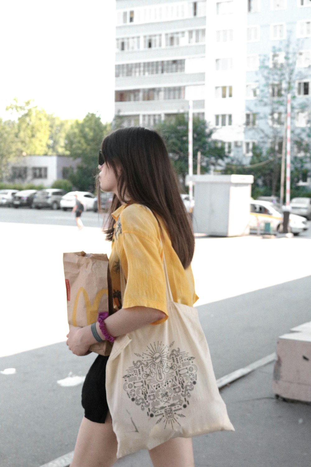 갈색 종이 봉지를 들고 노란색 긴 소매 셔츠를 입은 여자