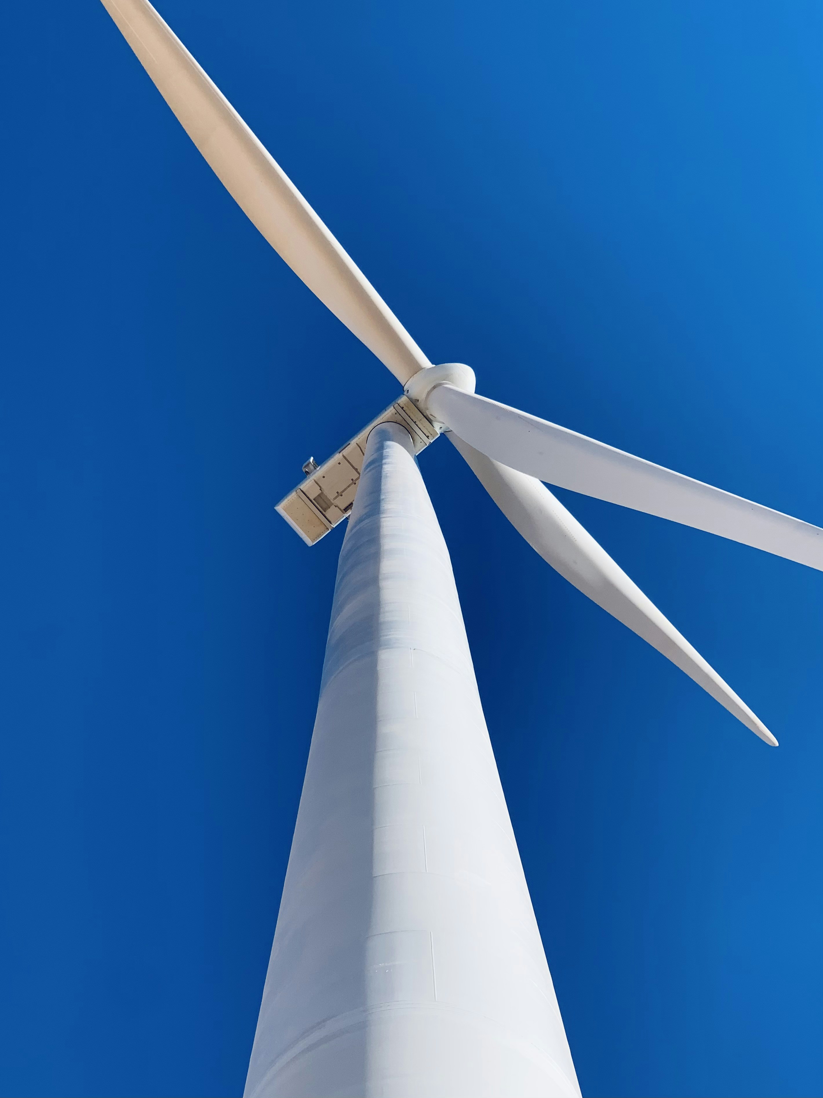 white wind turbine under blue sky during daytime