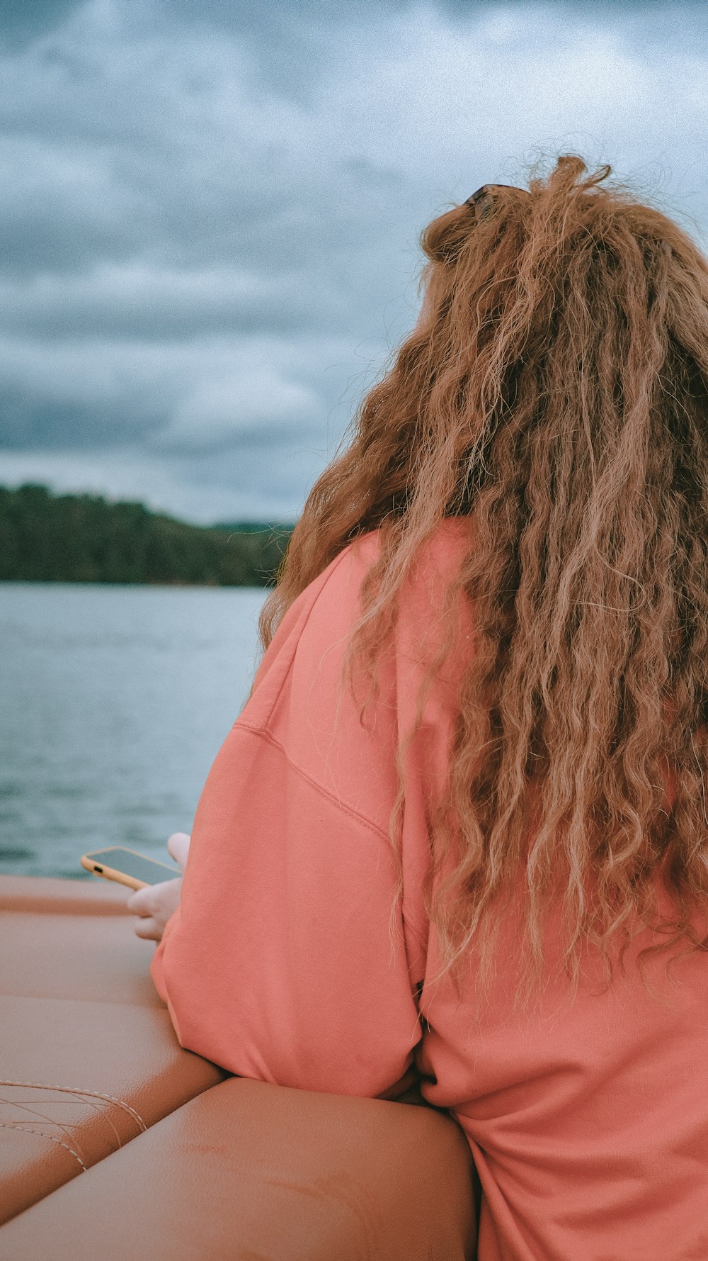 woman in pink shirt standing near body of water during daytime