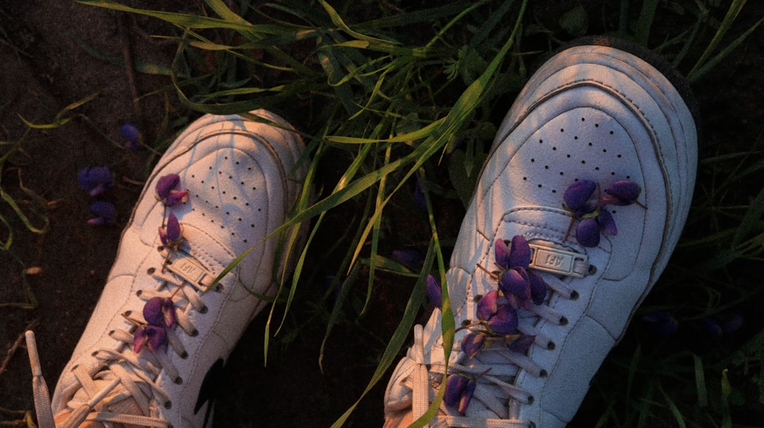 white and pink nike sneakers on green grass