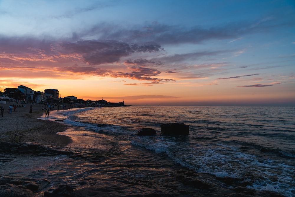 silhouette of buildings near sea during sunset