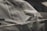 A close-up of masking tape being applied to a car surface for painting.