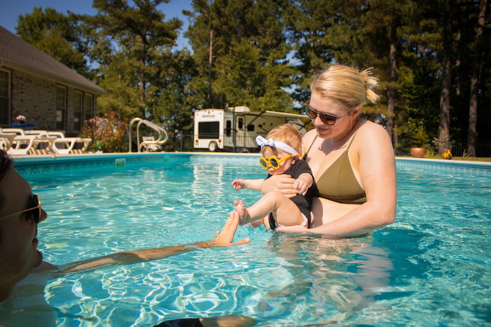 woman in black bikini top and black sunglasses in swimming pool during daytime