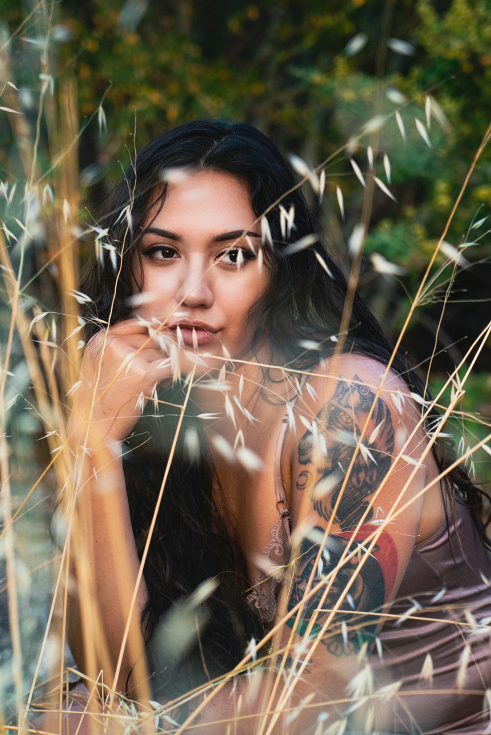 woman in black and orange floral shirt sitting on grass field