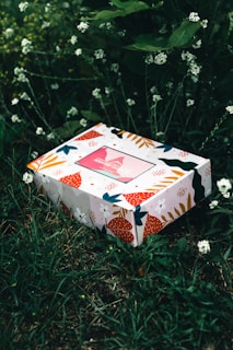 white and red floral box on green grass