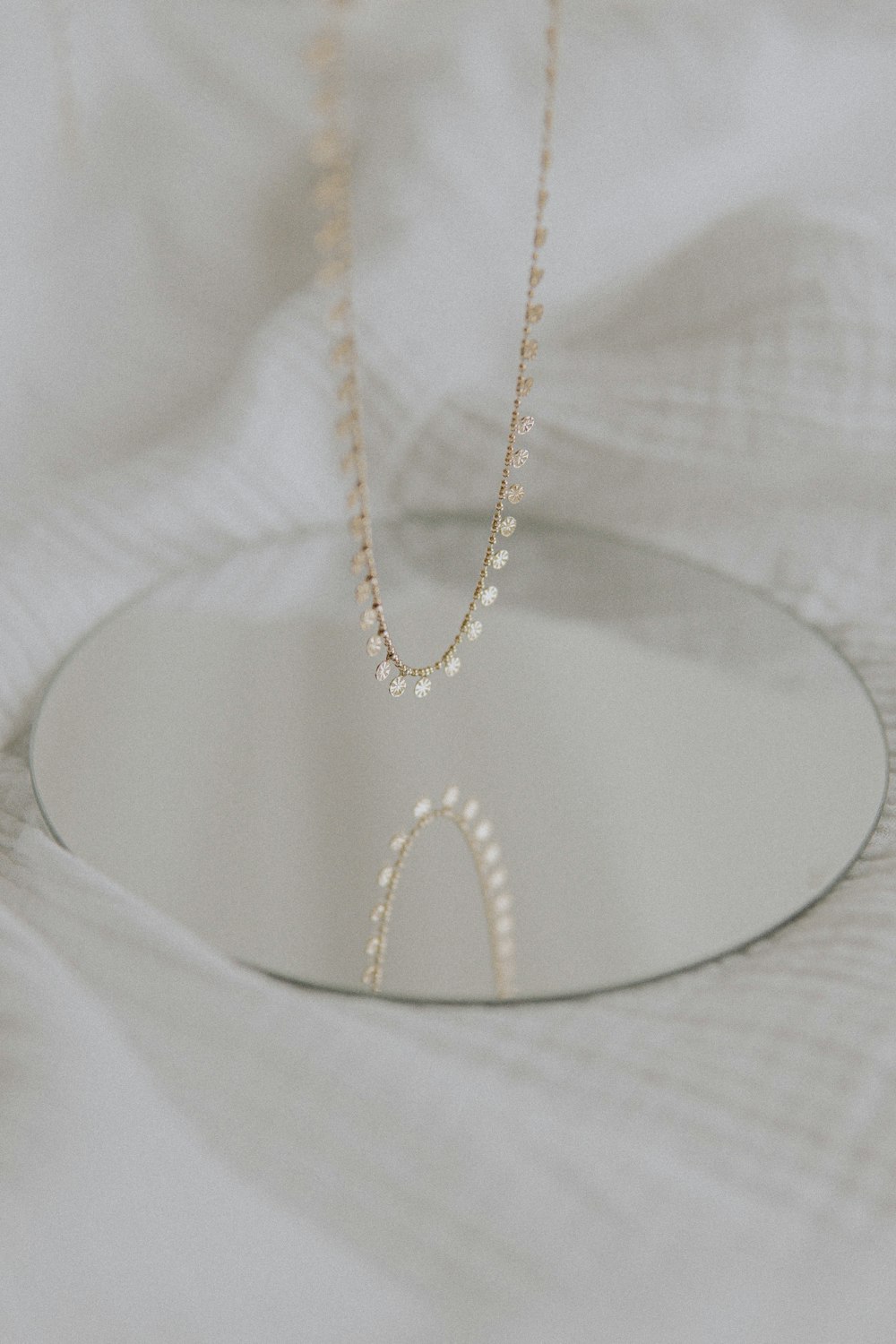 gold necklace on white textile