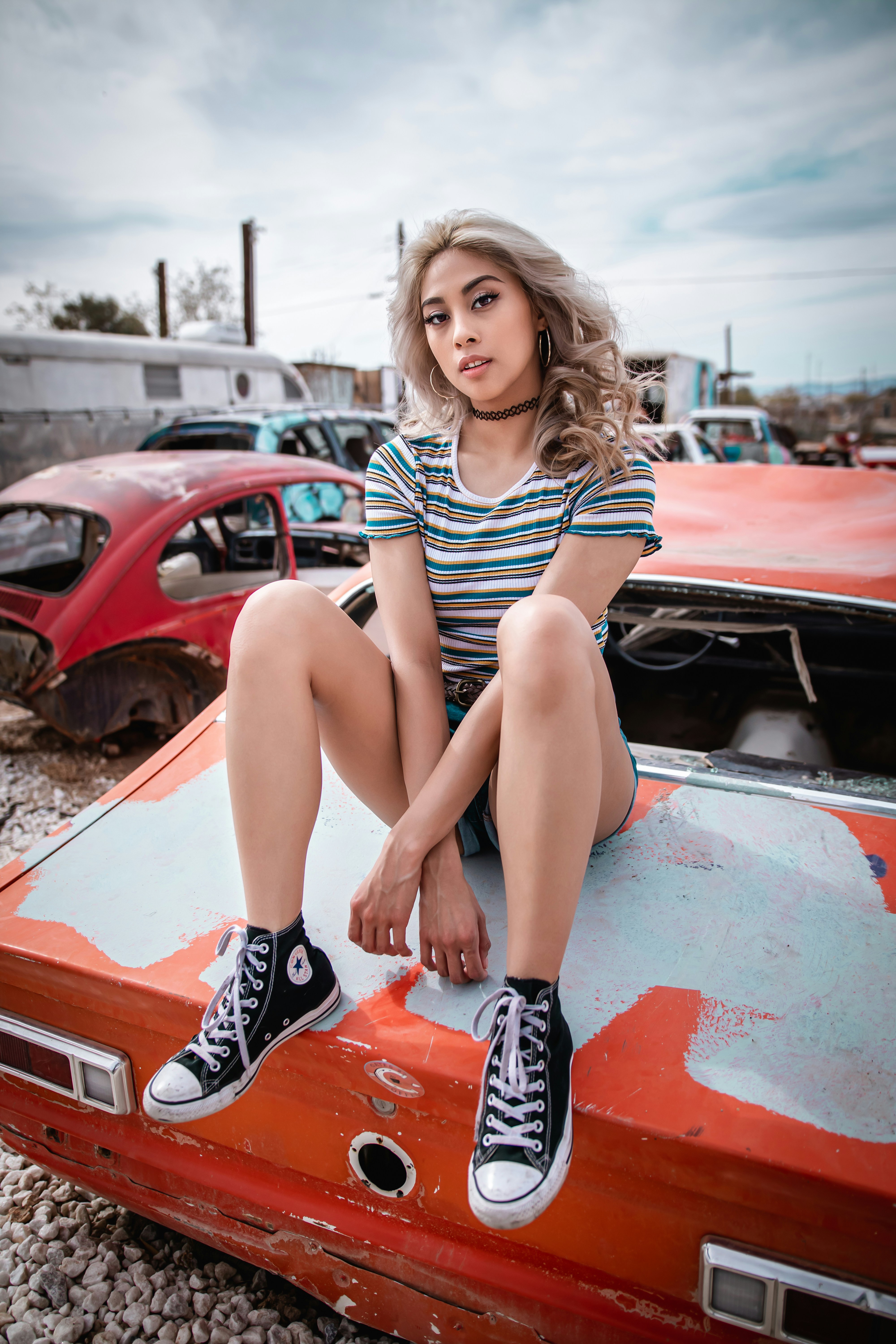 woman in black and white stripe tank top sitting on red car