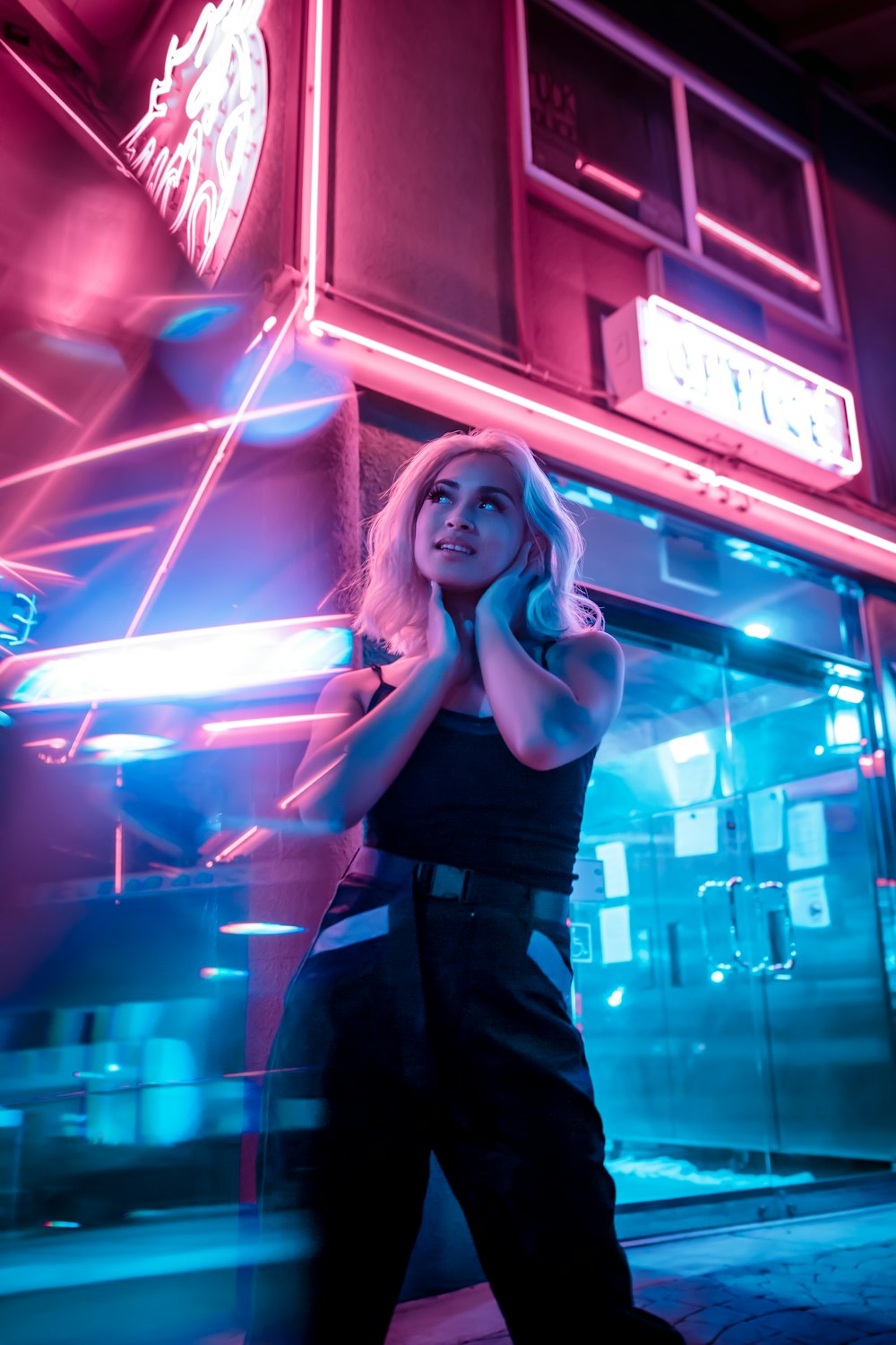 woman in black tank top standing near red led light