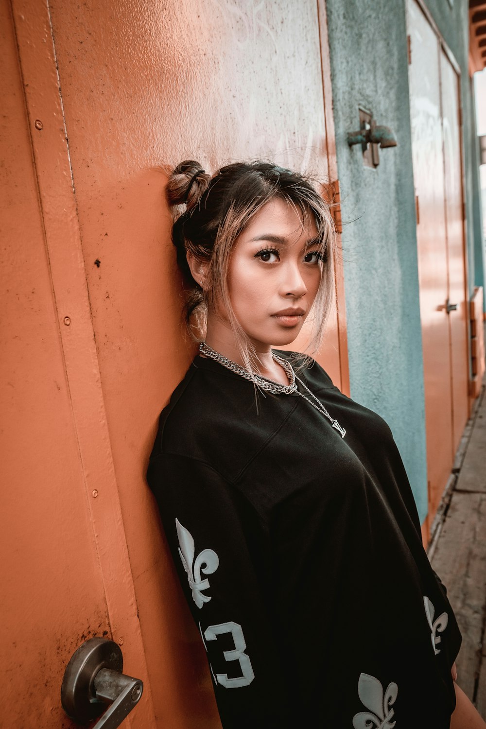 woman in black zip up jacket standing beside red door