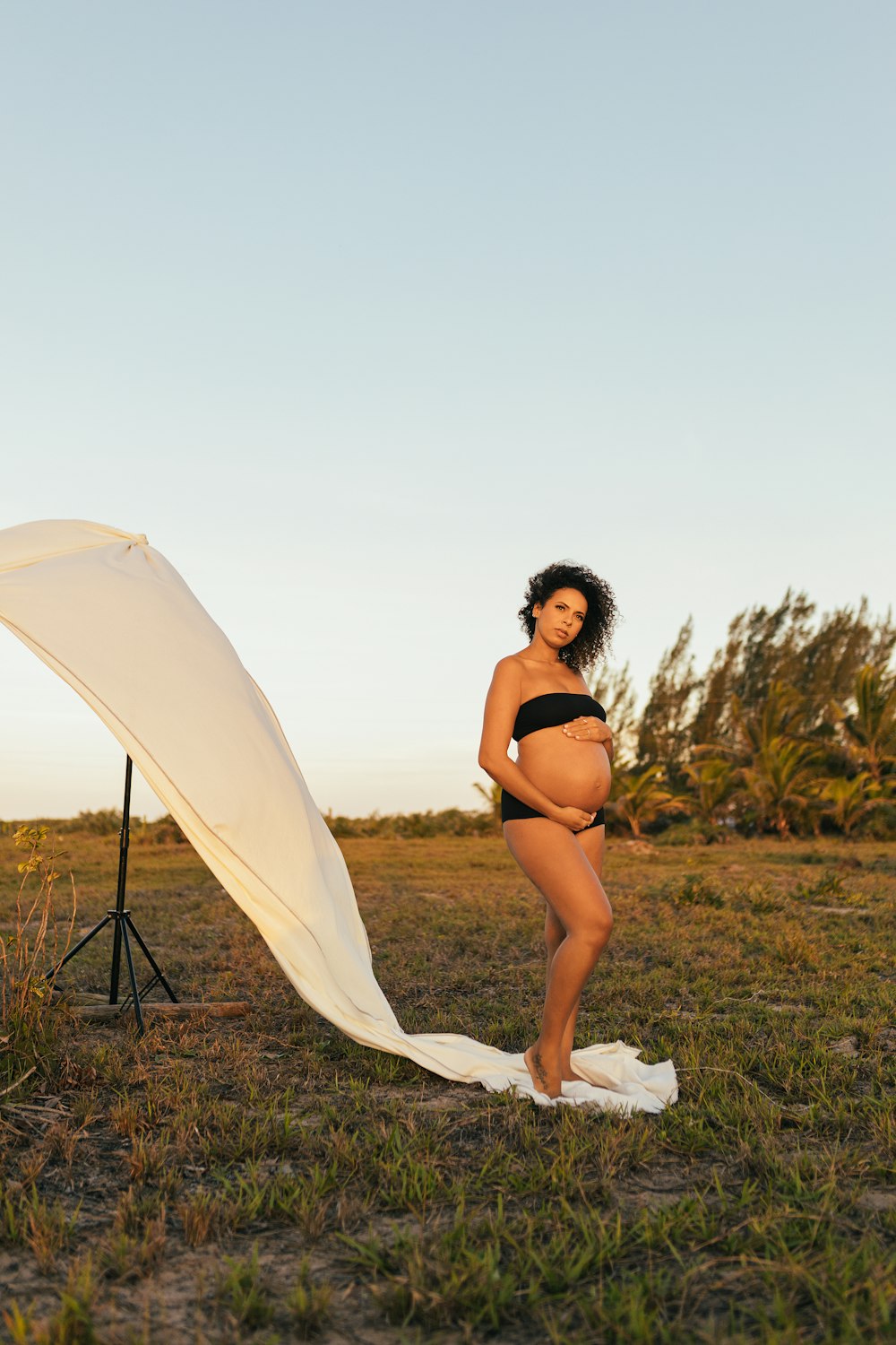 woman in black bikini sitting on white textile