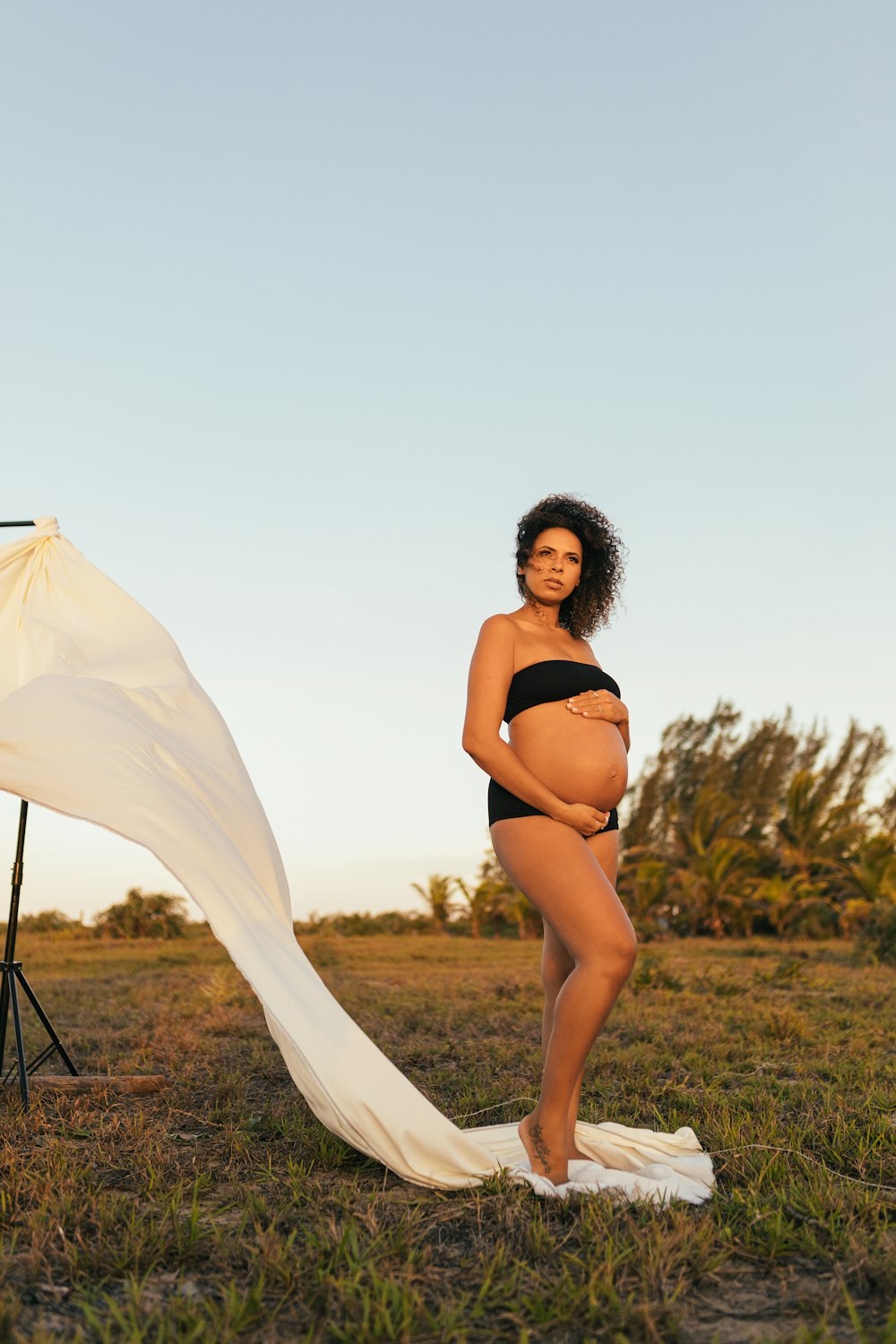 woman in black bikini standing on green grass field during daytime