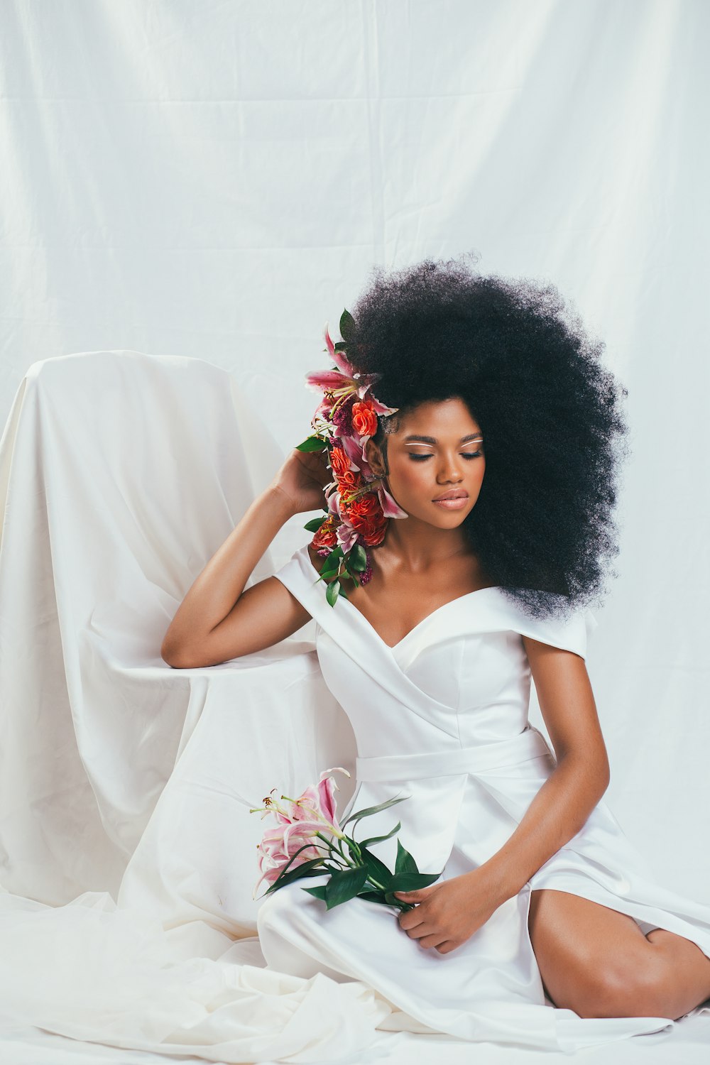 woman in white dress holding red rose