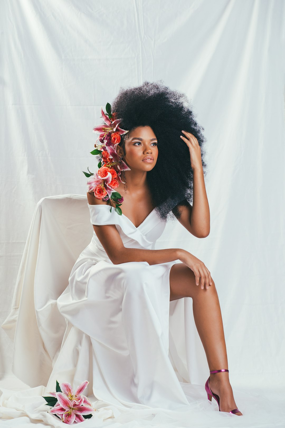 woman in white dress holding red rose bouquet