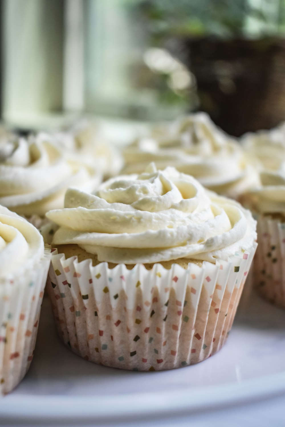 white cupcake on white and red polka dot paper