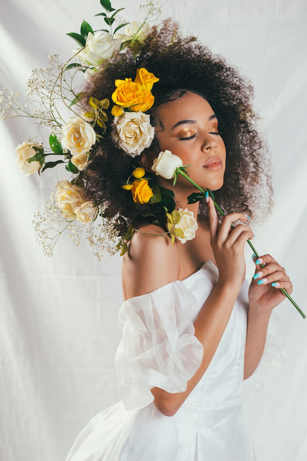 woman in white off shoulder dress holding yellow and white flower bouquet