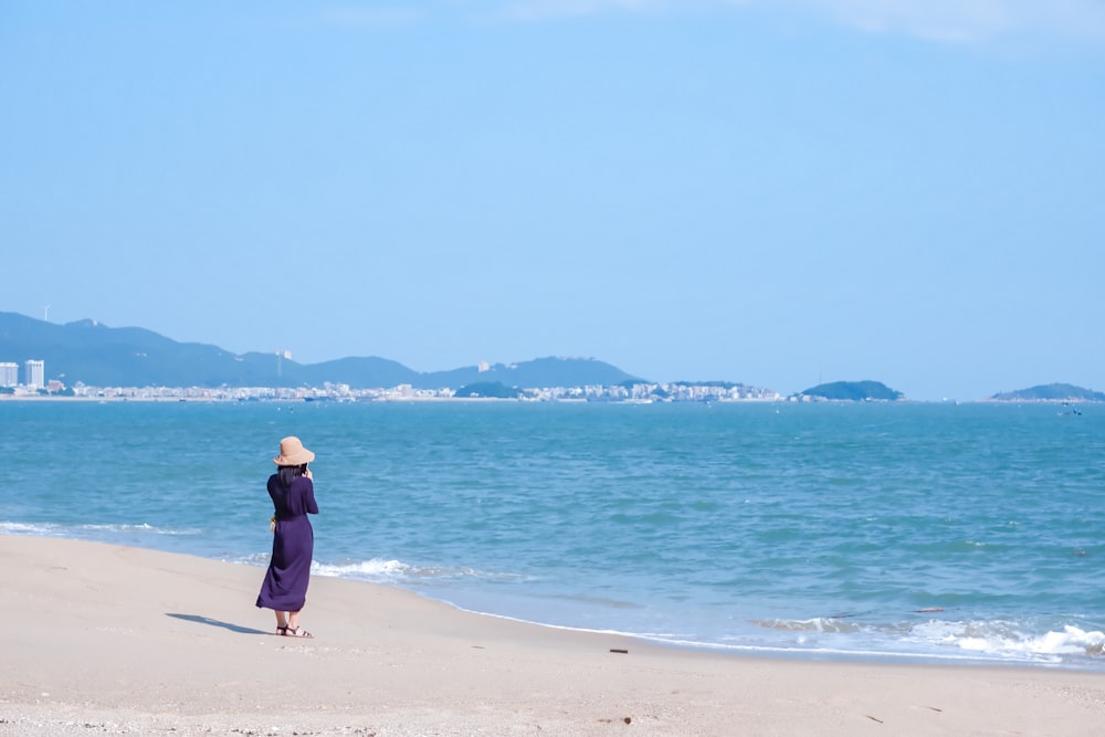 man in blue jacket and black pants walking on beach during daytime