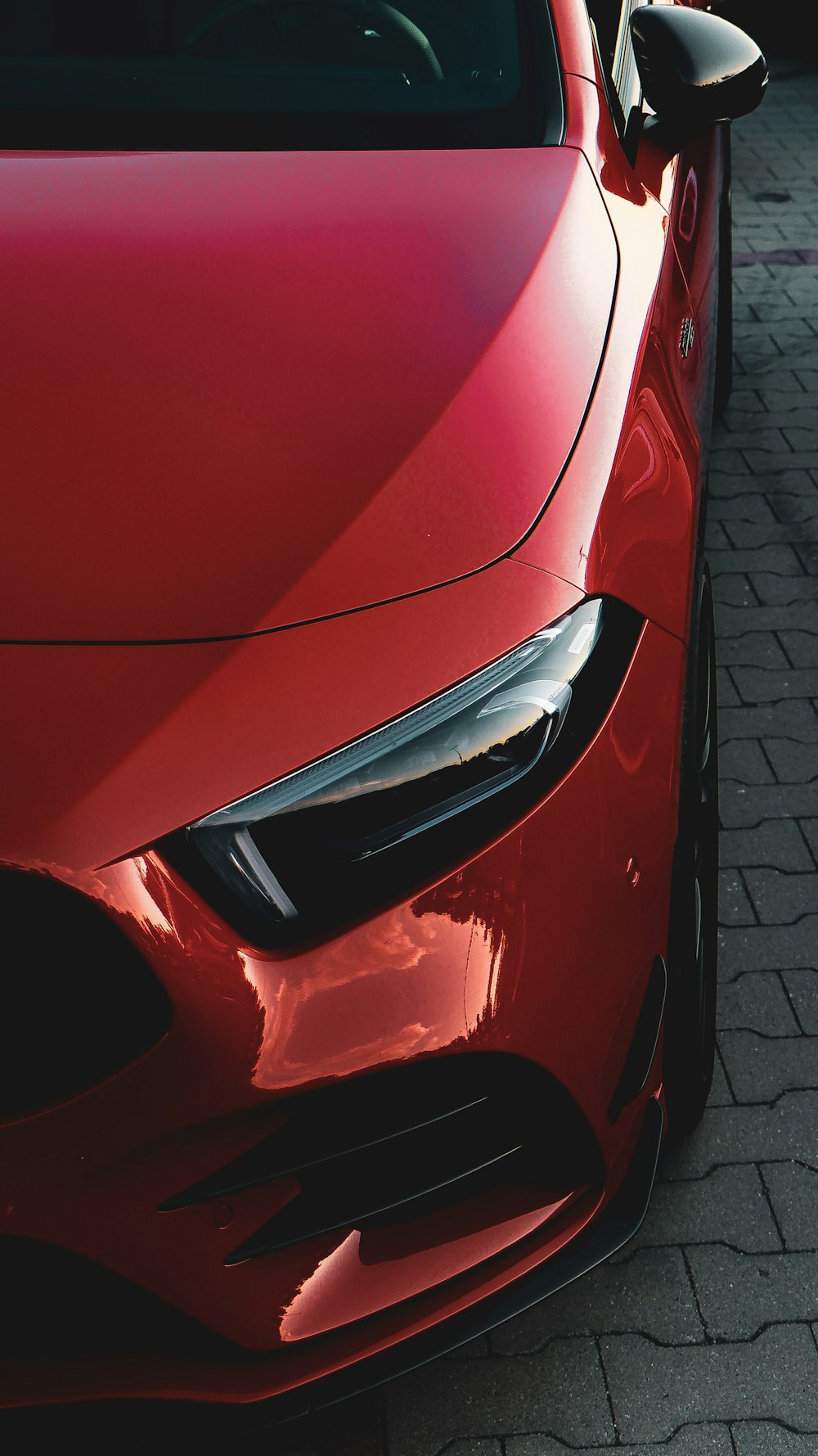 red car on gray brick pavement