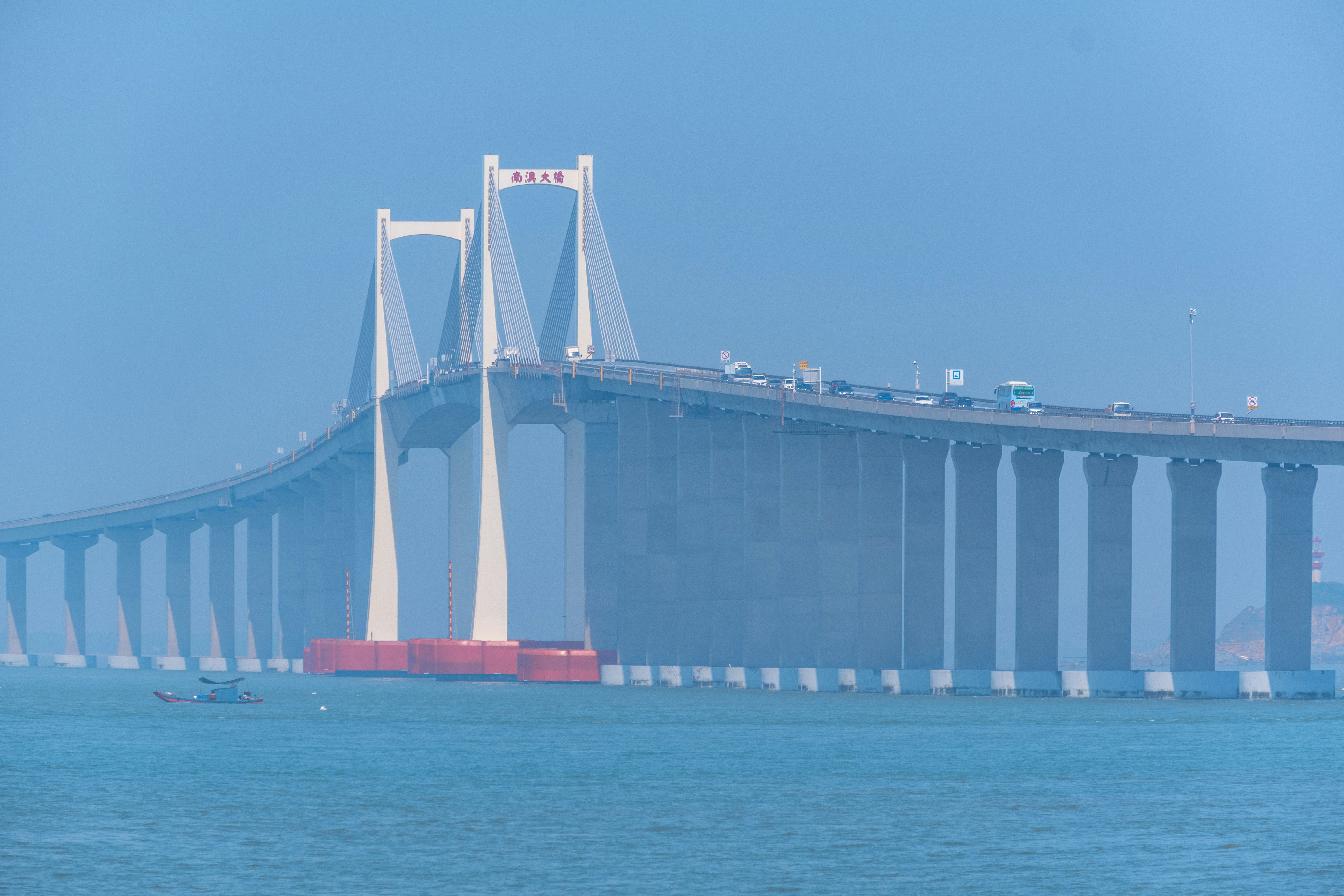 white and red bridge over blue sea during daytime