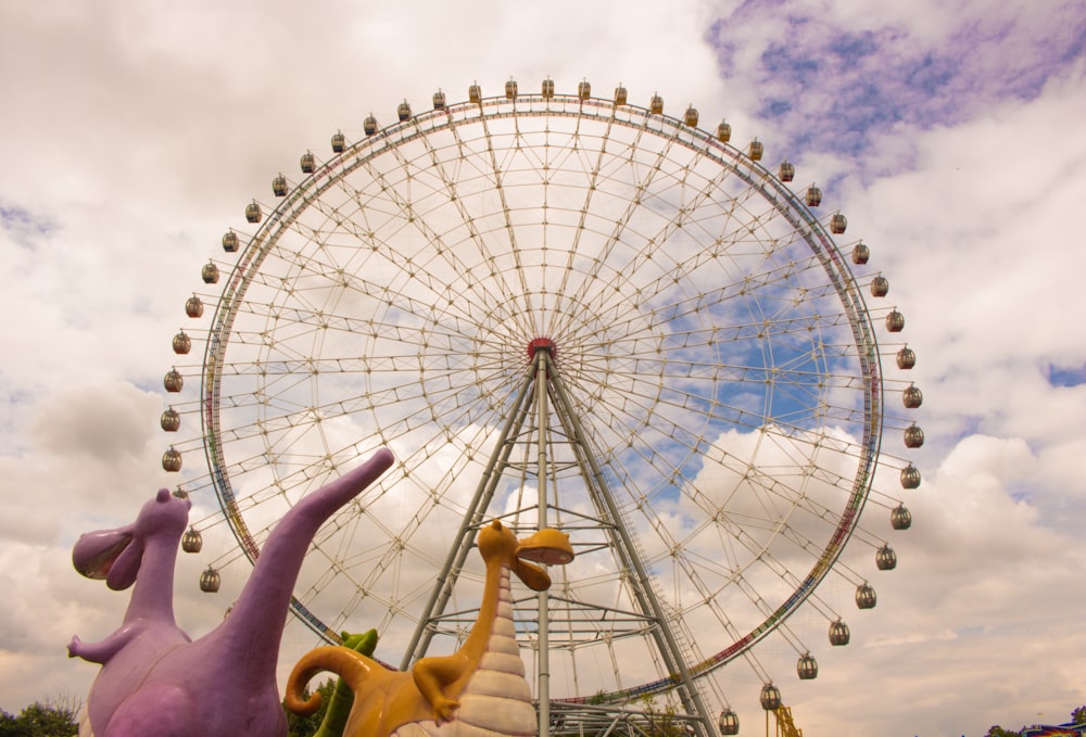 white ferris wheel under white clouds during daytime