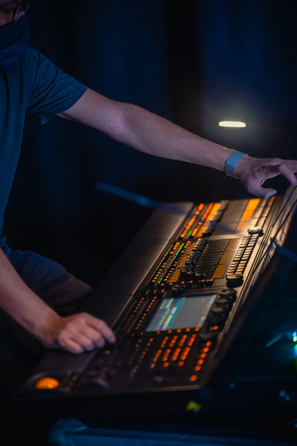 person in blue t-shirt playing audio mixer