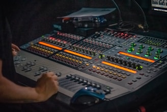 person holding gray and black audio mixer