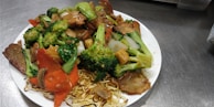 A steaming dish of quick-cooked stir-fry with assorted vegetables.