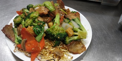 Close-up of sizzling stir-fry noodles with vibrant vegetables.