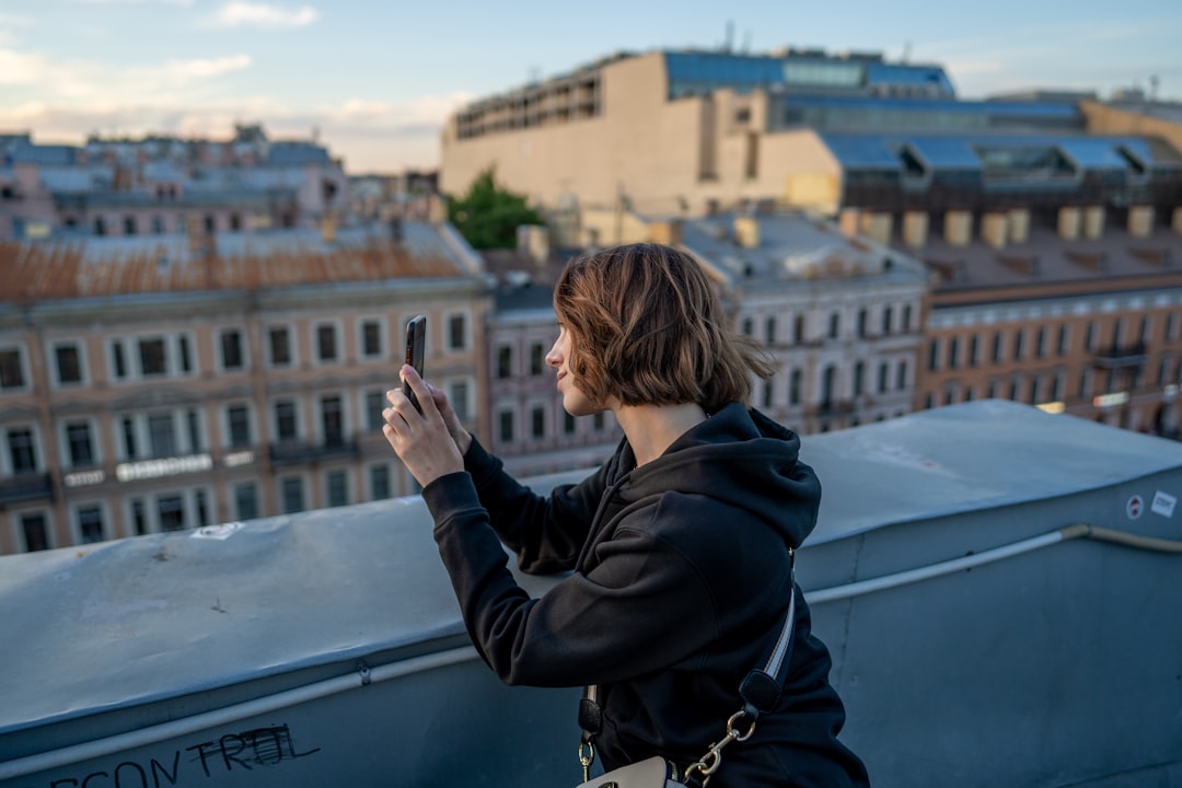 woman in black hoodie standing on top of building during daytime