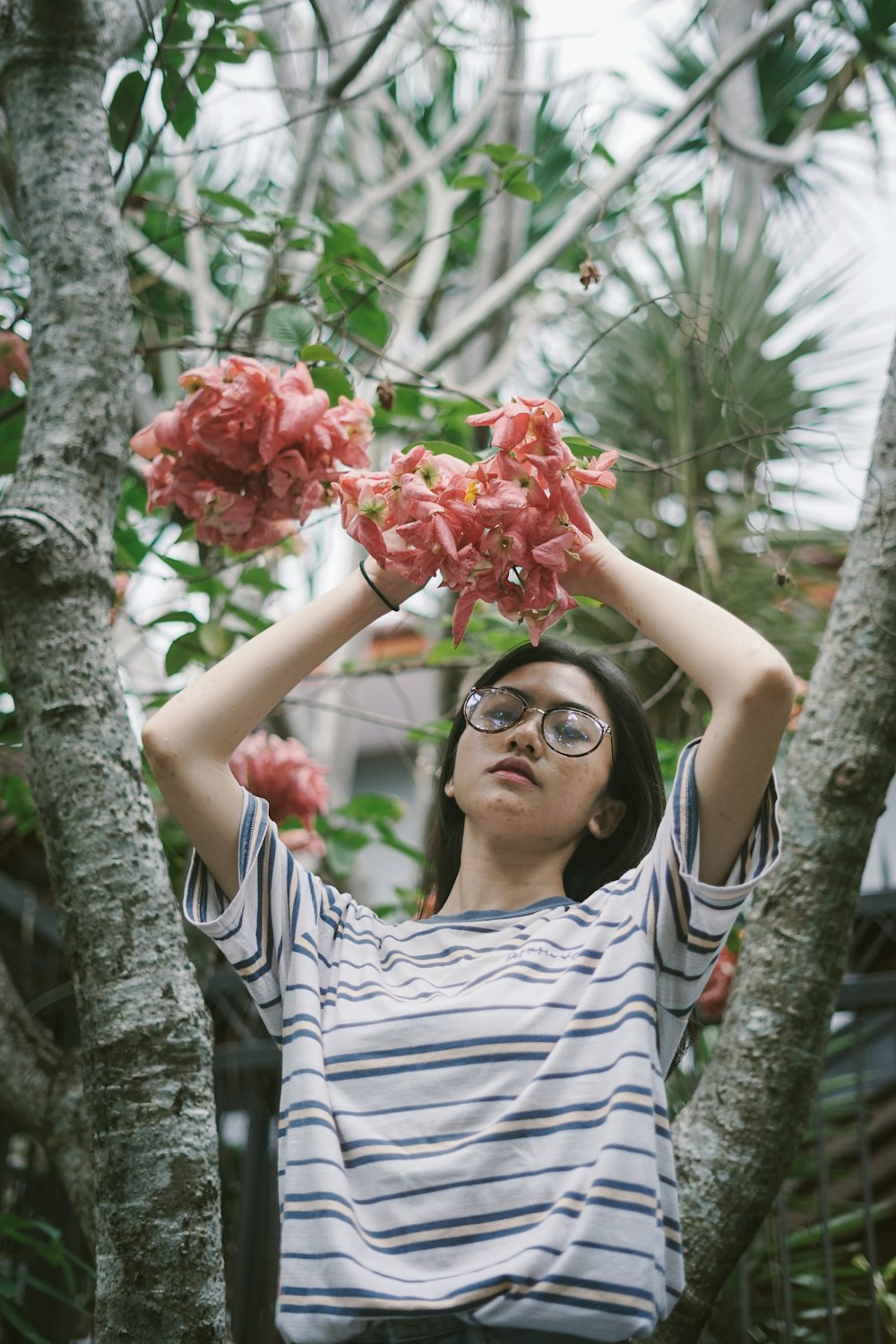 woman in black and white stripe shirt holding red flower