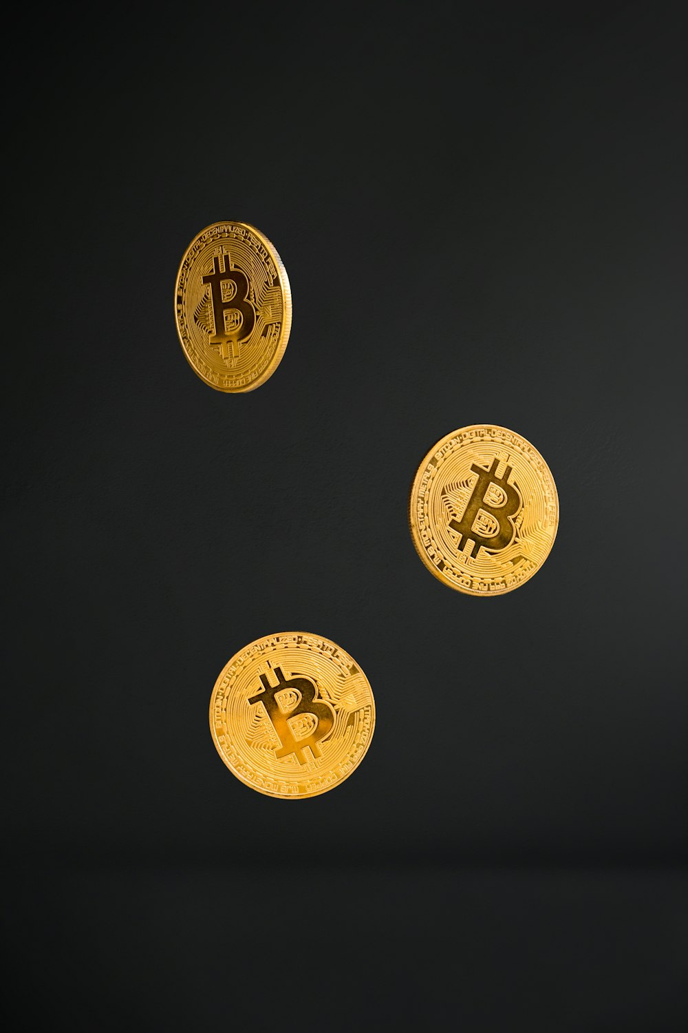 3 gold round coins on black background