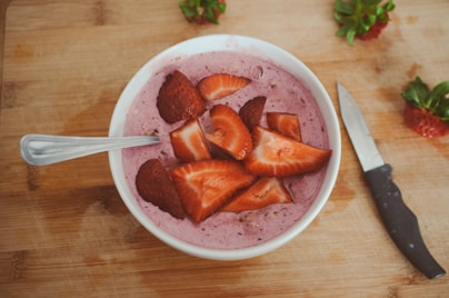 sliced strawberries in white ceramic bowl