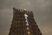 lighted street light on top of brown concrete building