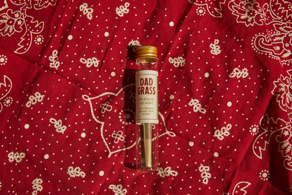 white labeled bottle on red and white floral textile