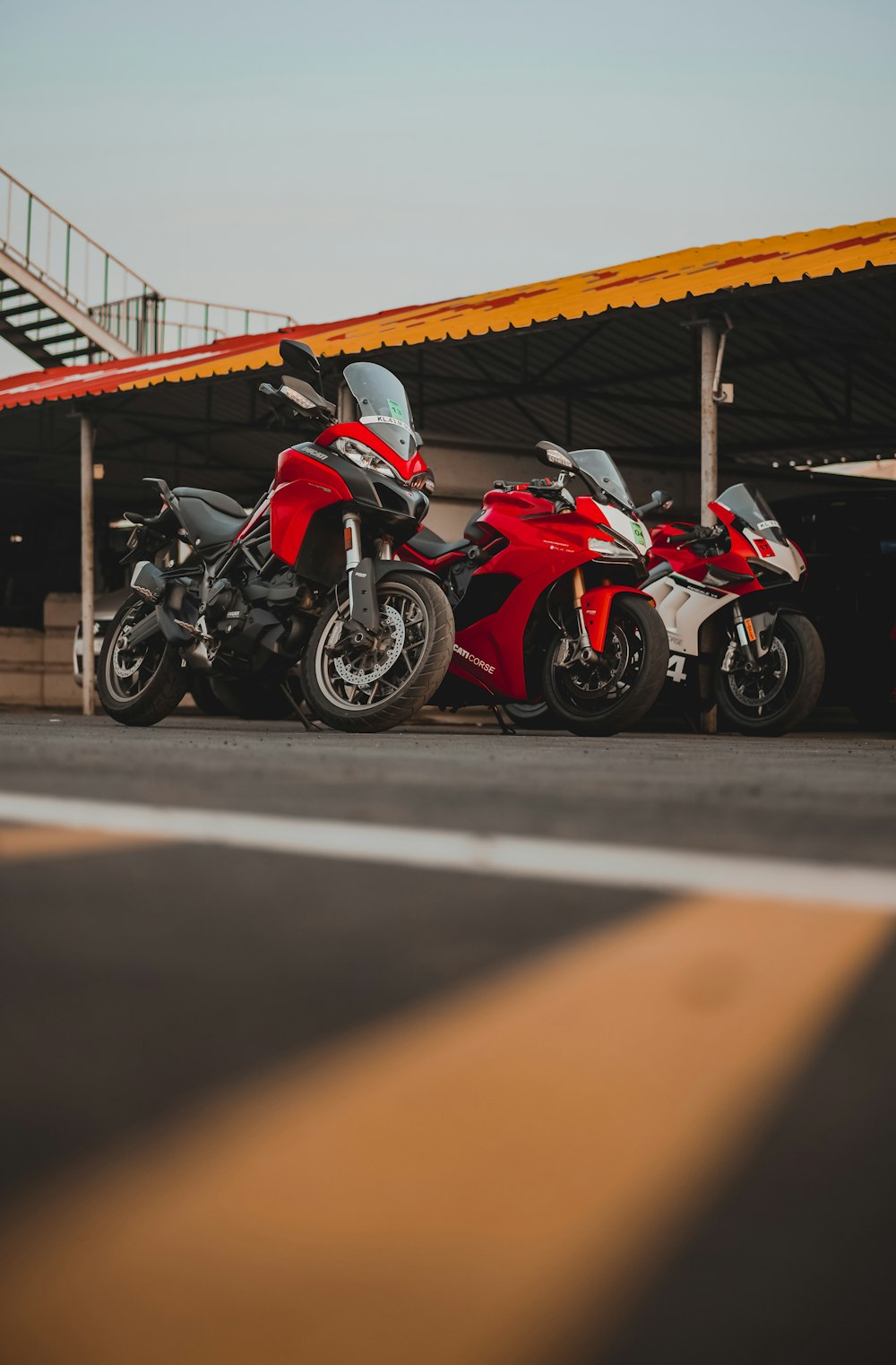 red and black sports bike parked on parking lot during daytime