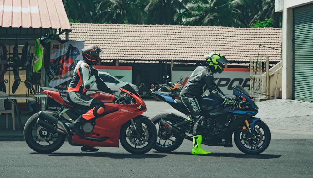 2 men riding on red sports bike during daytime