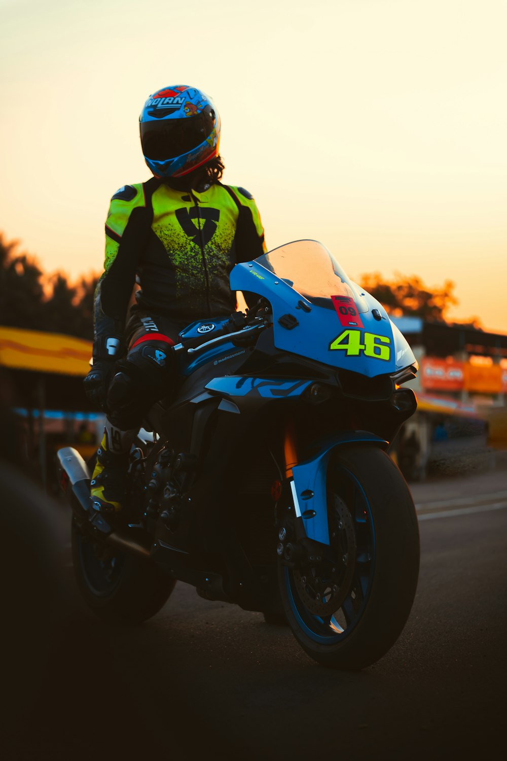 homme en veste noire conduisant une moto pendant la journée