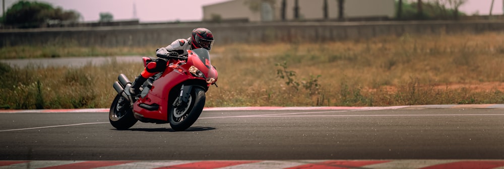 man in red motorcycle helmet riding red sports bike on road during daytime