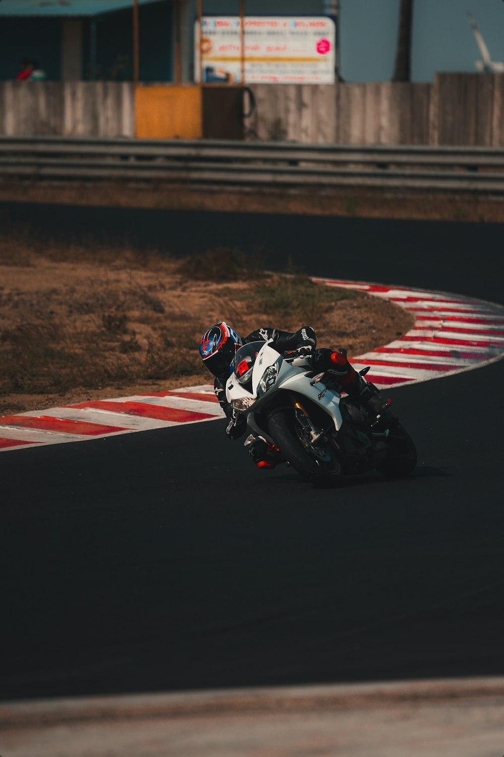 hombre en traje de motocicleta blanco y negro montando en bicicleta deportiva