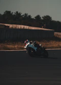 Rider leaning into a sharp turn on a racetrack with blurred background.