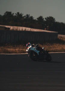 A rider leaning into a sharp curve on a mountain road at sunset.