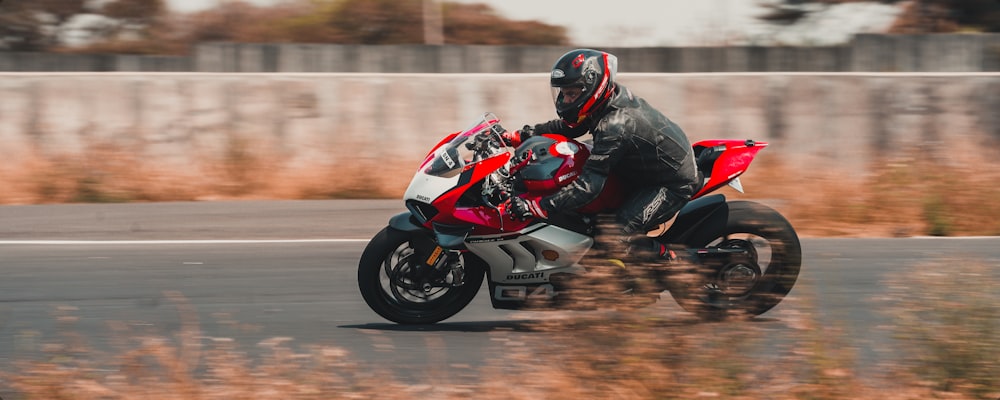 man in red and black motorcycle suit riding on sports bike