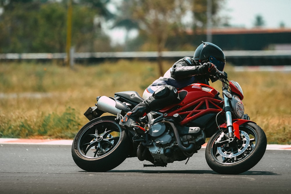 man in orange and black motorcycle suit riding motorcycle on road during daytime