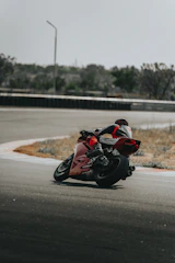 An instructor guiding a rider through cornering techniques on a sunny track day.