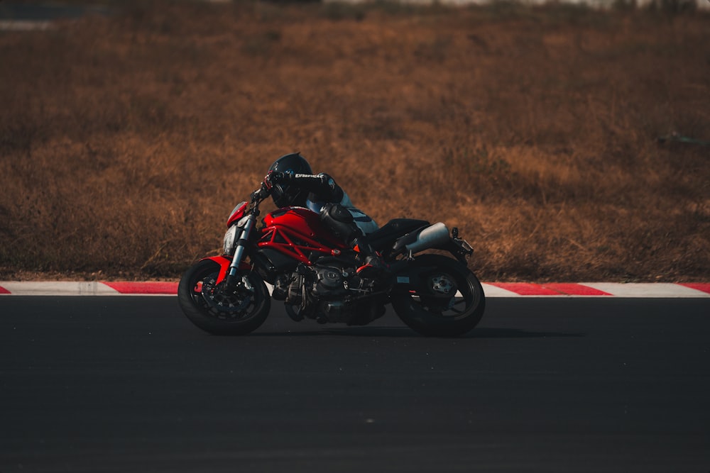 man in black motorcycle suit riding on black sports bike