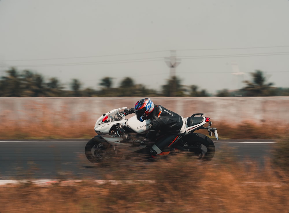 man in black and white motorcycle suit riding on motorcycle