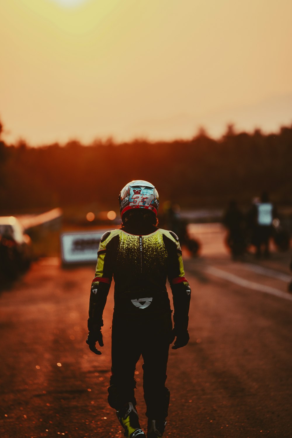 man in green and black jacket standing on road during daytime