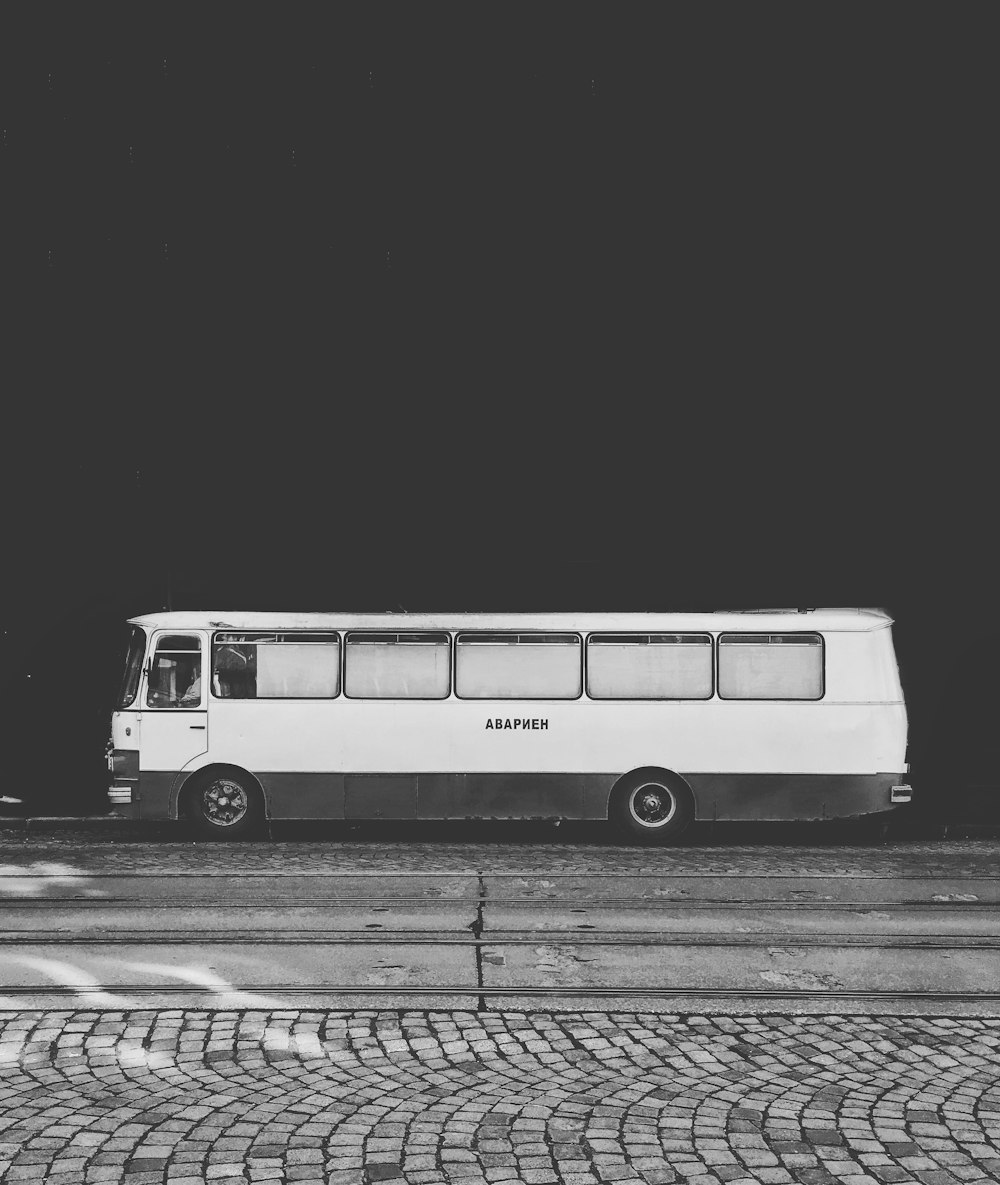 Photo en niveaux de gris d’un bus sur la route