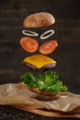 food photography,how to photograph levitation of delicious burger on wooden background; two burger with lettuce and tomato