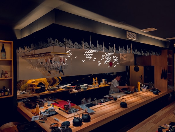 A bustling sushi bar with chefs preparing dishes behind a minimalist counter in a premium atmosphere.