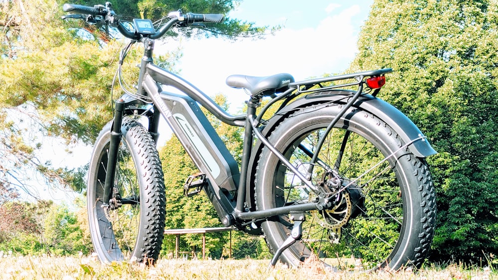 white and black commuter bike on green grass field during daytime